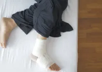 다리를 감싸 쥐고 있는 모습